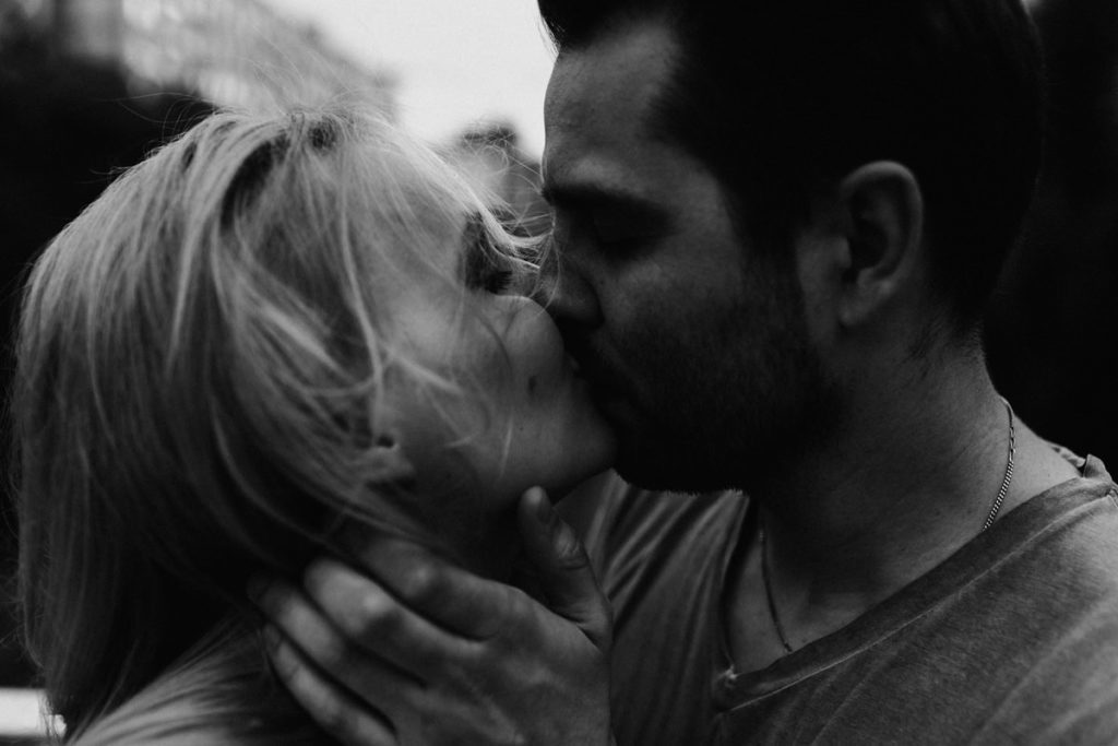 Emotional and intimate portrait of a couple kissing on the street. Intimate engagement photosession London. Free spirits, wild hearts, young couple kiss.